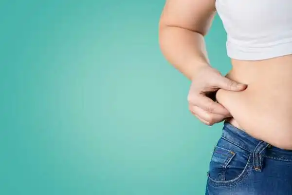 Image of woman pinching her love handles to show weight gain Tamworth